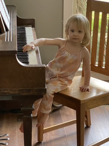 Little girl sitting at the piano